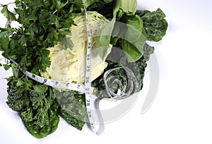 Healthy diet health foods with leafy green vegetables and tape measure.