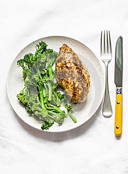 Healthy diet lunch - baked chicken breast and boiled broccoli cabbage on a light background, top view