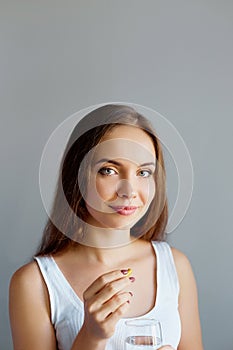 Healthy Diet Nutrition. Portrait Of Beautiful Smiling Young Woman Taking Vitamin Pill. Closeup Of Happy Girl Holding Colorful Caps