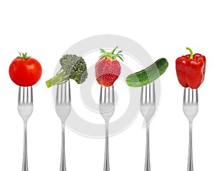 Healthy diet, organic food on forks with vegetables and berries.