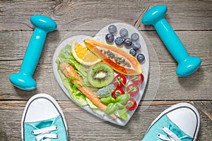 Healthy diet and sport concept with dumbbells trainers and food