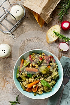 Healthy dietary vegan dish: couscous and vegetables string beans, brussels sprouts, carrots, sweet peppers, tomatoes on a stone