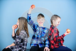 Healthy dieting and vitamin nutrition. Boy and girls friends eat apple snack while relaxing. School snack concept. Group