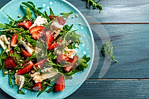 Healthy dish. Salad strawberry, aragula and brie, camembert cheese. Concept vegan and healthy eating. Top view. Diet dinner or