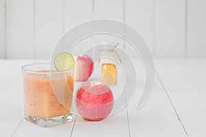Healthy drink,Reduce cholesterol in the blood vessels of smoothies with red apple and lemon, Honey bottle in a glass on white