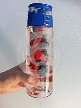 Strawberries blueberries in water bottle infuser