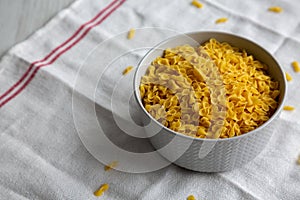 Healthy Dry Farfalline Pasta in a Bowl, side view. Space for text