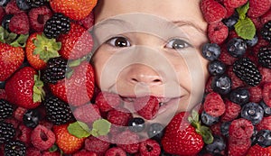 Healthy eating. Berries child face close up. Top view photo of child face with berri. Berry set near kids face. Cute