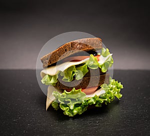 Healthy eating breakfast concept, food background. Closeup of vegetarian sandwich on slate board.