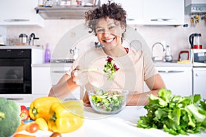 Healthy eating concept. Black woman eating vegetables salad portrait