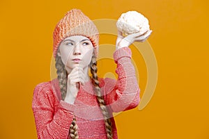 Healthy Eating Concepts. Thinking Caucasian Girl In Coral Knitted Clothing Posing With Cauliflower as a Demonstration of Human