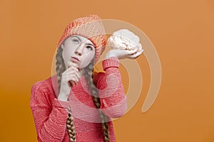 Healthy Eating Concepts. Thinking Caucasian Girl In Coral Knitted Clothing Posing With Cauliflower as a Demonstration of Human
