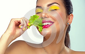 Healthy eating, diet. Beautiful healthy girl eating raw vegan food and smiling. Beauty young fashion woman eats green fresh lettuc