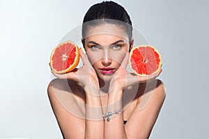 Healthy eating, diet. Beautiful healthy model girl with slices of red grapefruit, food, cosmetics concept