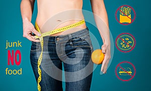 Healthy eating, diet and fitness concept. No junk food. Healthy female body with orange and measuring tape.