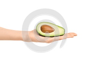 Healthy eating and diet Topic: Human hand holding a half avocado isolated on a white background in the studio