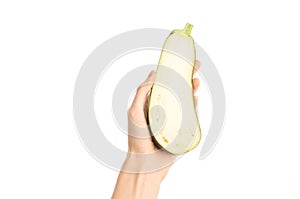 Healthy eating and diet Topic: Human hand holding a half eggplant isolated on a white background in the studio, first-person view