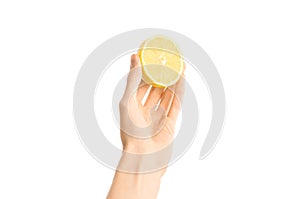 Healthy eating and diet Topic: Human hand holding half of lemon isolated on a white background in the studio, first-person view