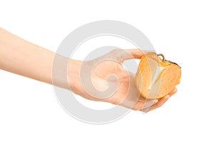 Healthy eating and diet Topic: Human hand holding a half of persimmons isolated on white background in the studio