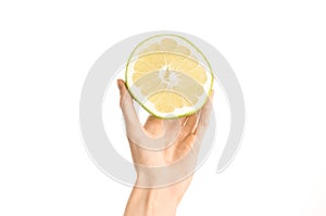 Healthy eating and diet Topic: Human hand holding a half sweetie isolated on white background in the studio, first-person view