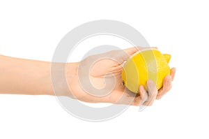 Healthy eating and diet Topic: Human hand holding yellow lemon isolated on a white background in the studio