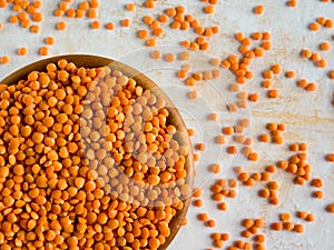 Healthy eating and dietary. Bowl of raw red lentil on white wooden background. Top view. Flat lay. Masoor Dal or Canadian Orange