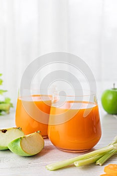 Healthy eating, dieting, food and vegetarian concept - glass with carrot juice, celery and green apple