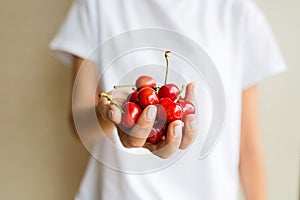 Healthy eating, dieting, vegetarian food and people concept- closeup of woman hand holding fresh berries cherry wearing white