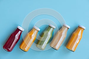 Healthy eating, drinks, diet and detox concept - close up of five bottles with different fruit or vegetable juices for detox plan.