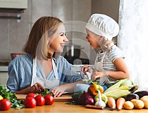 Healthy eating. family mother and child girl preparing vegetarian vegetable salad at home in kitchen