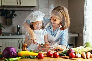 Healthy eating. family mother and child girl preparing vegetarian vegetable salad at home in kitchen