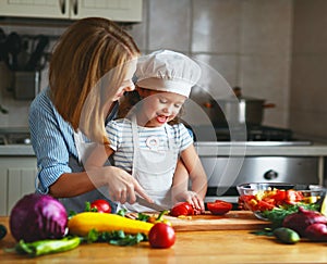 Healthy eating. family mother and child girl preparing vegetarian vegetable salad at home in kitchen