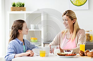 Happy family having breakfast at home kitchen