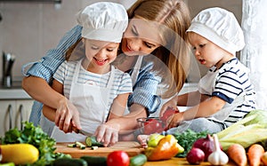 Healthy eating. Happy family mother and children prepares vegetable salad