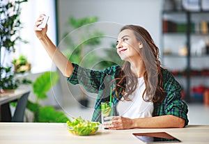 Healthy eating. happy young girl eating salad with tablet pc in morning in kitchen