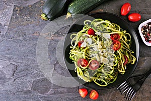 Healthy eating, low carb diet zucchini pasta. Top down view table scene on a dark slate background.