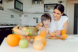 Healthy Eating. mom with baby eating fruits in the kitchen