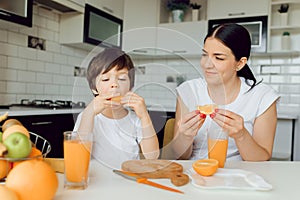 Healthy Eating. mom with baby eating fruits in the kitchen