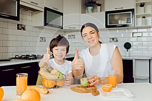 Healthy Eating. mom with baby eating fruits in the kitchen