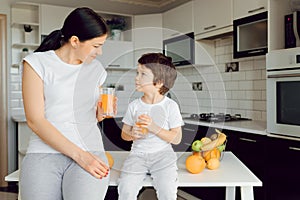 Healthy Eating. mom with baby eating fruits in the kitchen