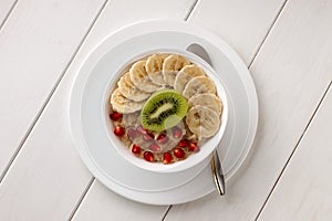 Healthy eating with oatmeal in a bowl on white wooden table.
