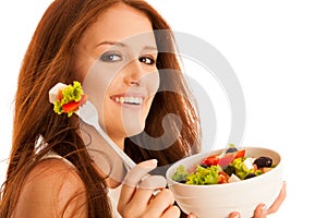 Healthy eating - woman eats a bowl of greek salad isolated over