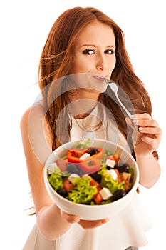 Healthy eating - woman eats a bowl of greek salad isolated over