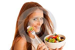 Healthy eating - woman eats a bowl of greek salad isolated over