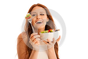 Healthy eating - woman eats a bowl of greek salad isolated over