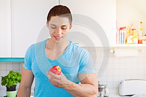 Healthy eating young man eat apple fruit in the kitchen copyspace