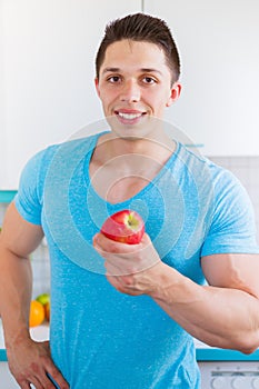 Healthy eating young man eat apple fruit in the kitchen portrait