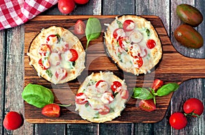 Healthy eggplant pizzas with melted mozzarella, tomatoes and basil