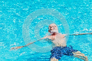 Healthy elder enjoy relax swimming in the swimming pool alone vacation holiday