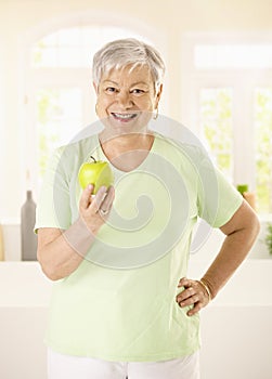Healthy elderly woman holding apple